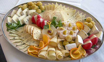 A platter with cheese and garnishes.