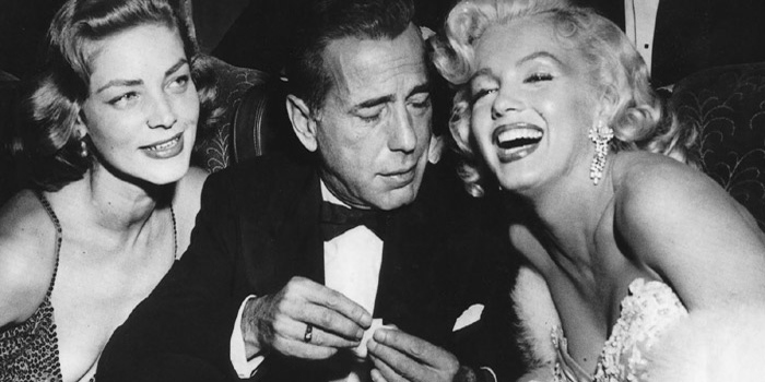 Humphrey Bogart (1899-1957) with Marilyn Monroe (1926-1962) and Lauren Bacall (1924-).